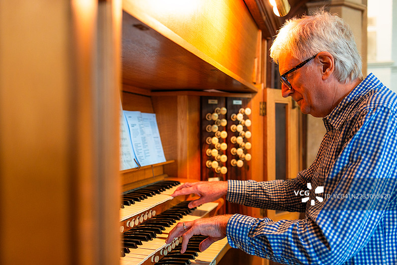 年长男性管风琴师在教堂演奏管风琴图片素材