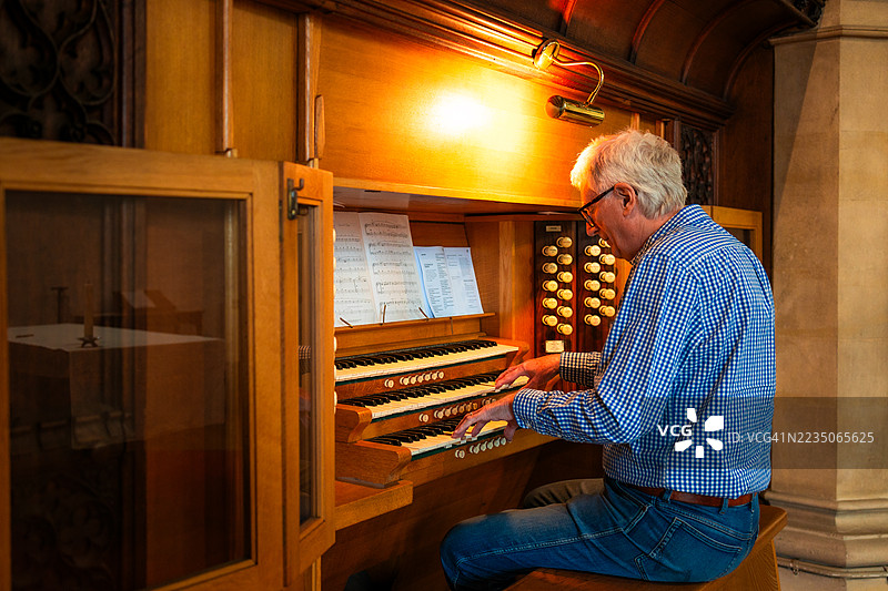 年长男性管风琴师在教堂演奏管风琴图片素材