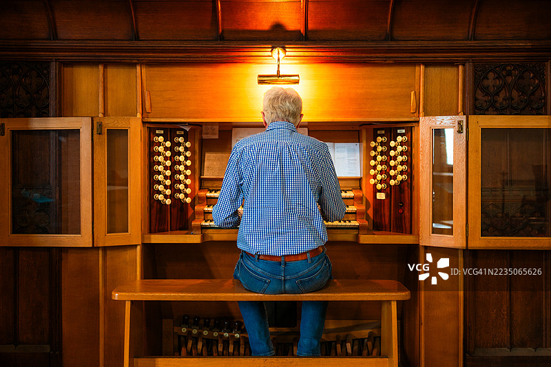 年长男性管风琴师在教堂演奏管风琴图片素材