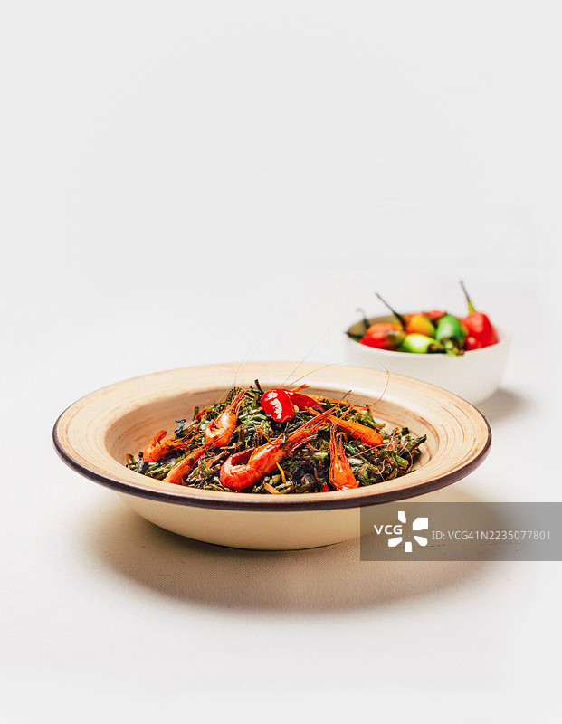 美味的虾仁和蔬菜炒菜，配有辣椒，背景为白色，随时可以享用图片素材
