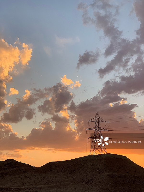 电力塔在戏剧性的日落天空下的剪影，伊朗塔布里兹图片素材