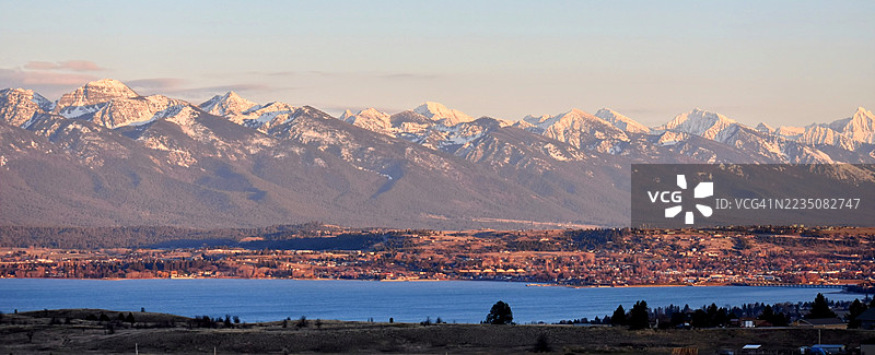 蒙大拿州波尔森的平头湖和雪山使命山脉的全景日落景色图片素材