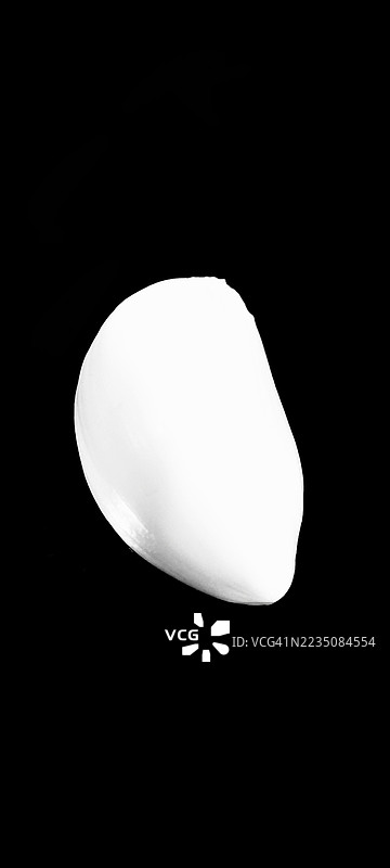 白色抽象形状的特写，光滑的曲线与深色背景形成对比，暗示着奢华的奶油或产品。图片素材