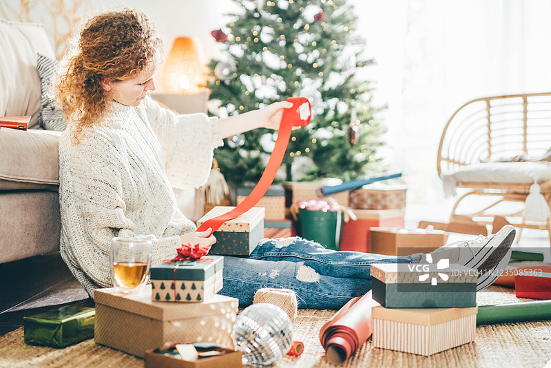 女人在家包装圣诞礼物。打包圣诞礼物。图片素材