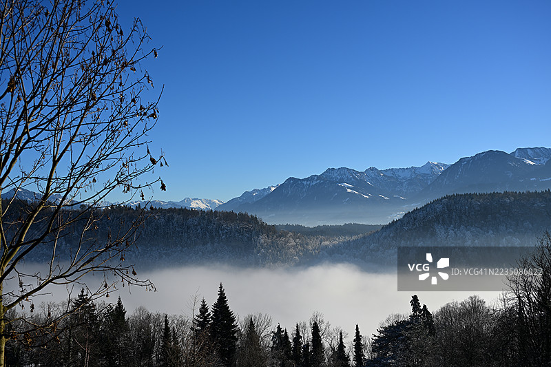 雄伟的冬季山脉风景，山谷中弥漫着雾气，湛蓝的天空，奥地利费尔德基兴图片素材