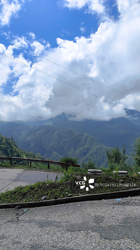 戏剧性的山地风景，蜿蜒的道路和多云的天空图片素材