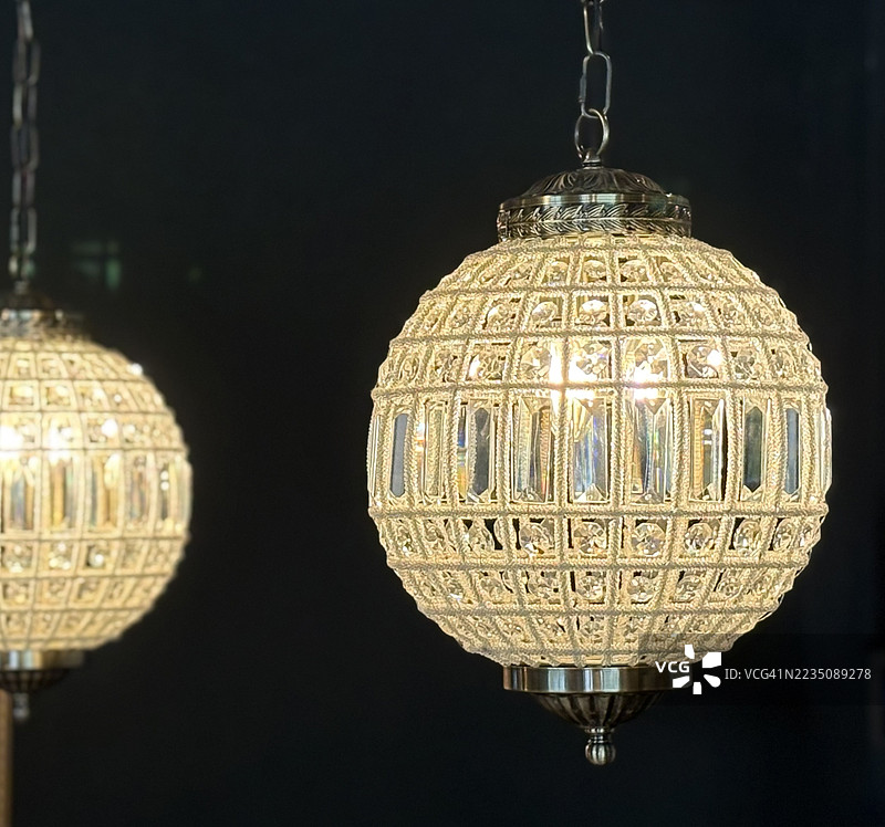 近距离拍摄灯光璀璨、造型华丽的水晶吊灯，悬挂在黑暗空间中，尽显奢华与优雅，美国印第安纳州诺布尔斯维尔图片素材