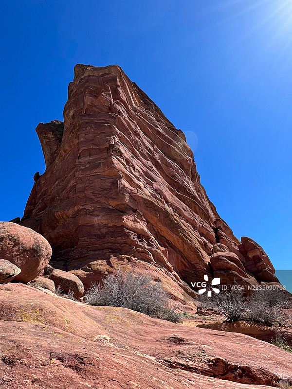 壮丽的红色岩石在灿烂的蓝天下，展现出大自然的宏伟。图片素材