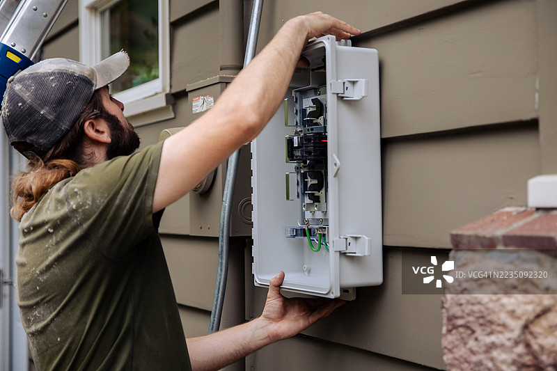 电工为太阳能面板系统接线盒接线图片素材