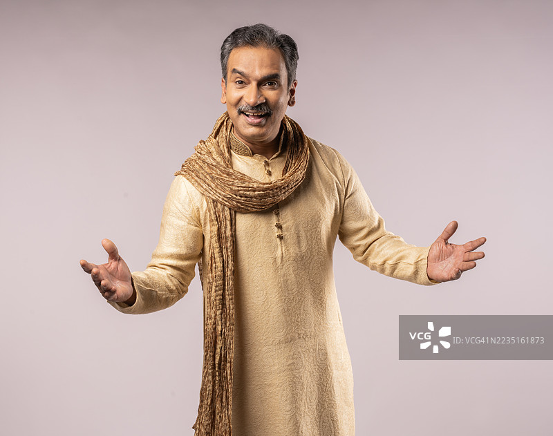 身穿传统服饰的男子在白色背景前摆姿势图片素材