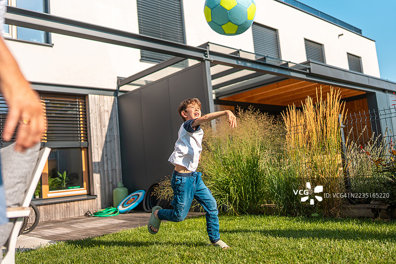 不同种族的小男孩在后院与白人祖母玩球图片素材