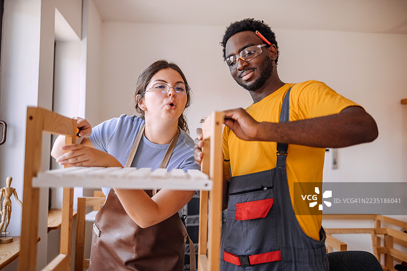 年轻人们在木工车间使用工具创业图片素材
