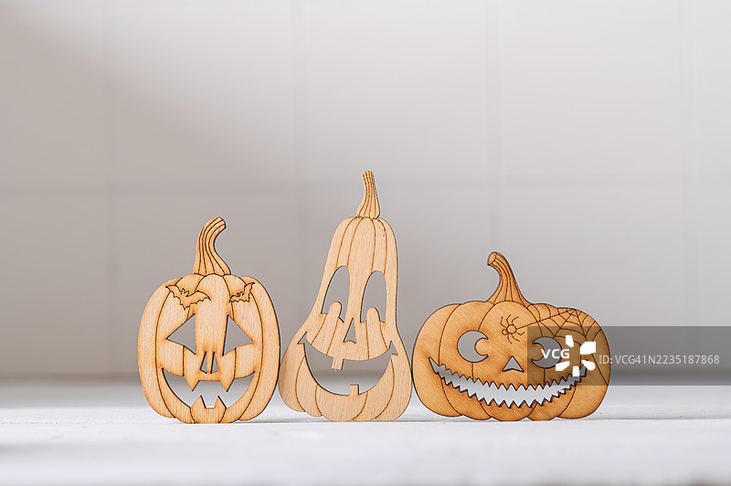 带有蝙蝠雕刻的木质万圣节南瓜剪影，背景为中性色调图片素材