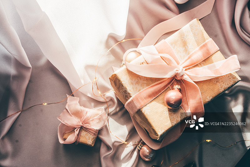 粉色圣诞礼物在柔和的背景上。圣诞节平面布置。图片素材