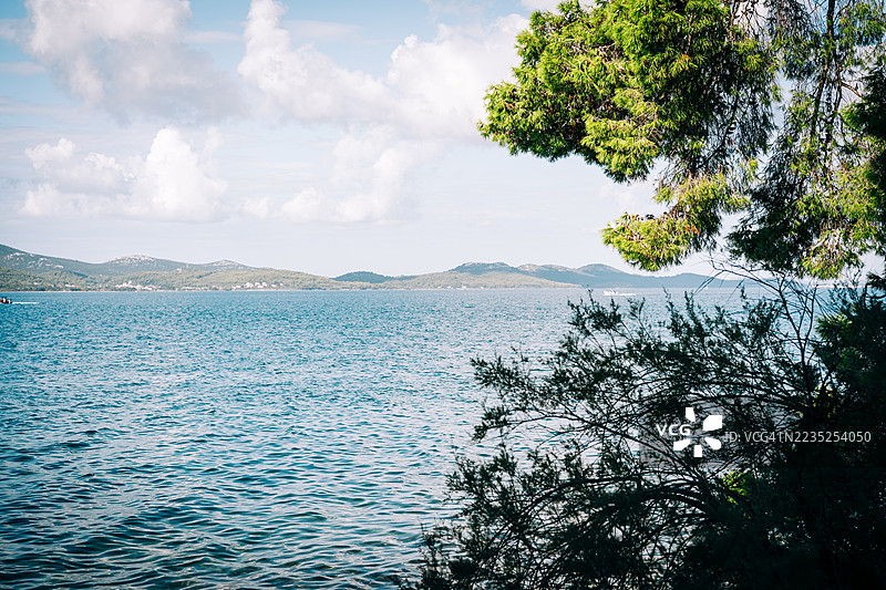 克罗地亚扎达尔的风景如画的海岸线，碧蓝的海水与郁郁葱葱的绿植相映成趣图片素材