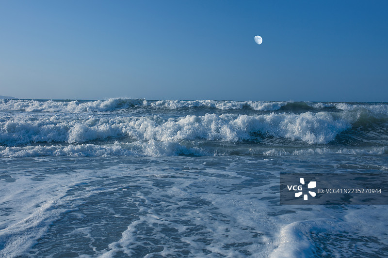 黄昏时分的暴风蓝色海洋与月亮图片素材