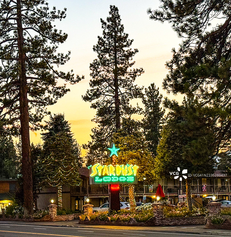 背光的松树和1960年代的星尘旅馆招牌，位于塔霍湖大道上图片素材