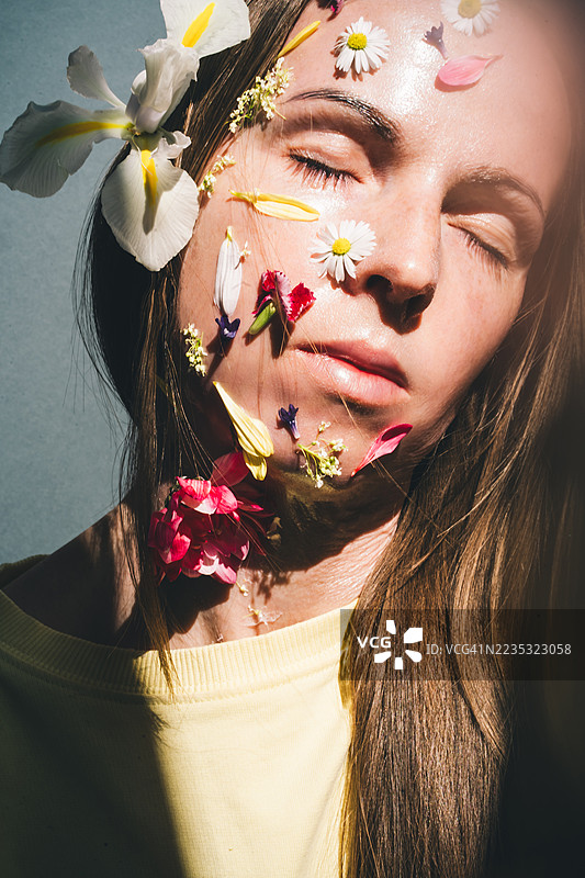 一位面部装饰着花朵的女性肖像，体现了一位中年女性逐渐消逝的美丽。图片素材