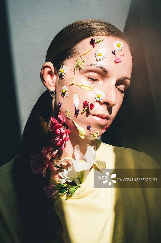一位面部装饰着花朵的女性肖像，体现了一位中年女性逐渐消逝的美丽。图片素材