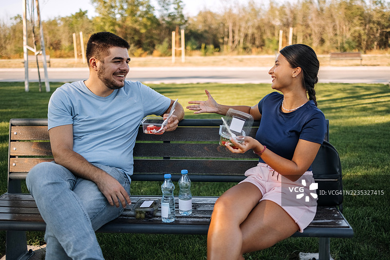 年轻人在公园午休，享用健康食品，心情愉悦图片素材