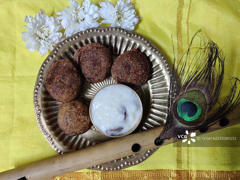 乌尼阿帕姆/乌尼亚帕姆/帕尔帕亚萨姆/米饭甜品/铜盘中的布丁/花朵/竹笛/黄丝绸上的孔雀羽毛/斯里克里希纳诞辰节/斯里克里希纳节/阿什塔米罗希尼节/节日/喀拉拉邦图片素材