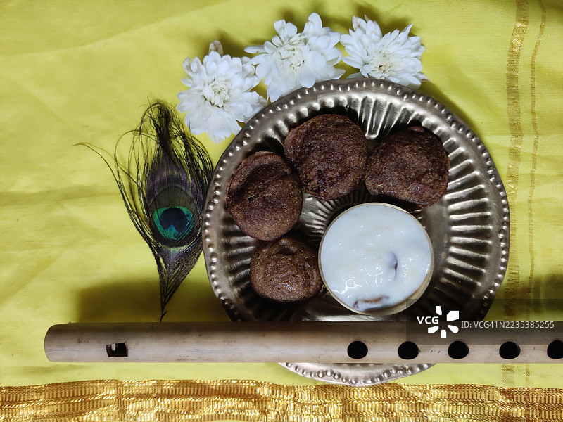 乌尼阿帕姆/乌尼亚帕姆/帕尔帕亚萨姆/米饭甜品/铜盘中的布丁/花朵/竹笛/黄丝绸布上的孔雀羽毛/斯里克里希纳诞辰节/斯里克里希纳节/阿什塔米罗希尼/节日/喀拉拉邦图片素材