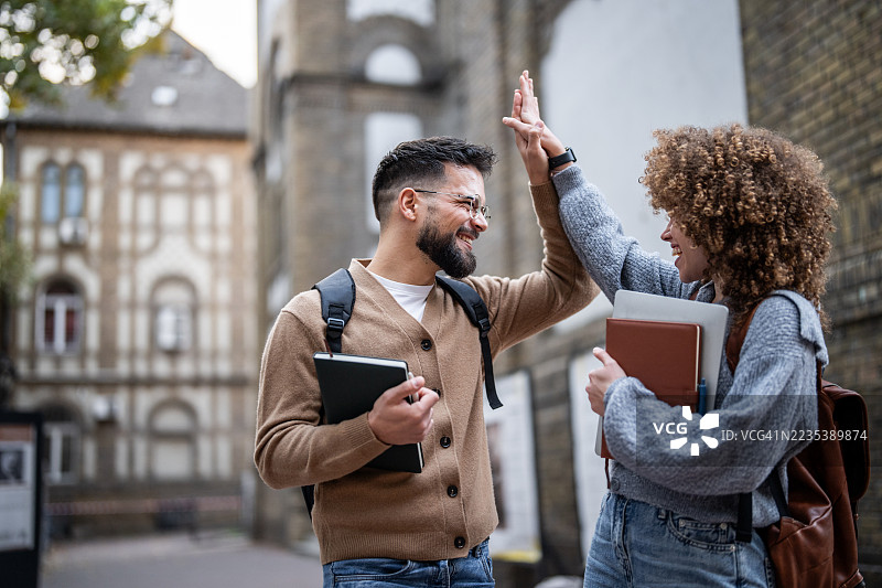 快乐的学生们在户外击掌庆祝成功图片素材
