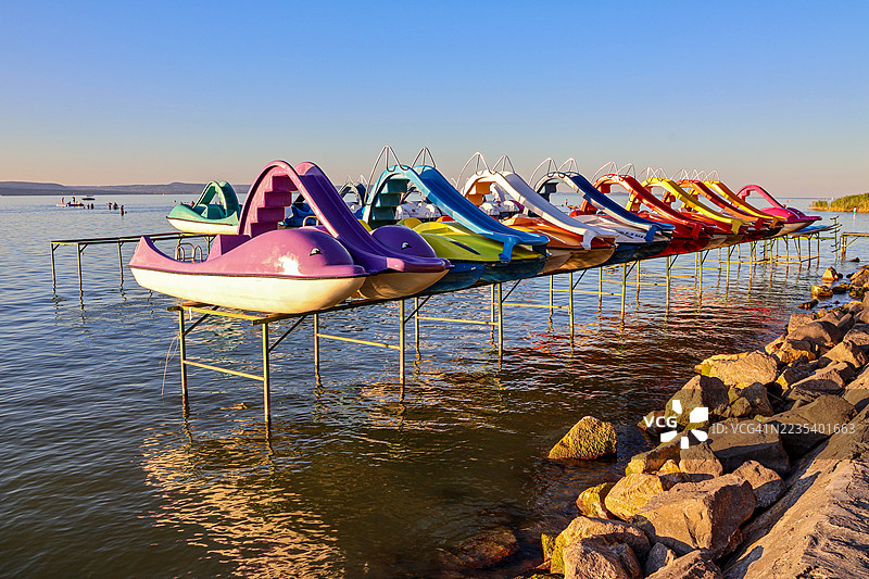 日落时分，五彩缤纷的脚踏船在巴拉顿湖上图片素材