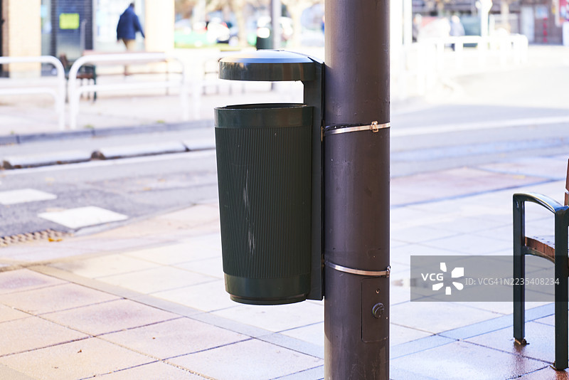 城市街道上固定在杆子上的公共垃圾桶图片素材
