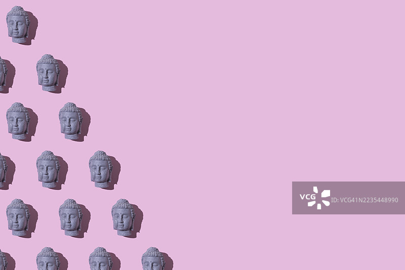 灰色石佛像头部的图案，位于左侧，背景为粉色。佛教，灵性，禅，神，信仰，和平，宁静，印度和泰国。图片素材