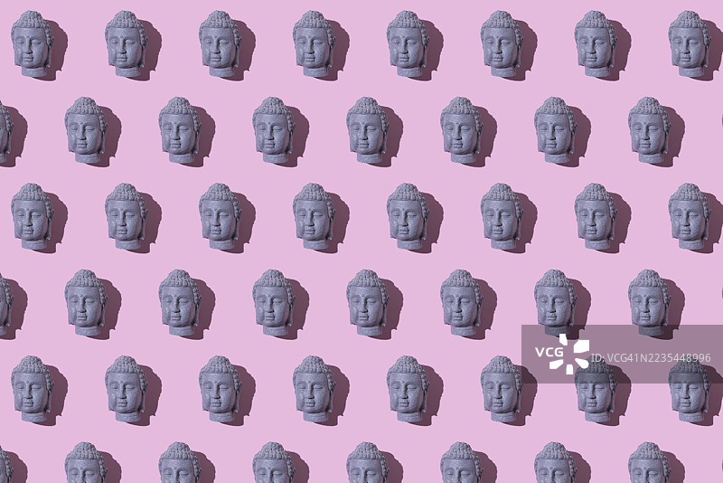 粉色背景上的灰色石佛像头部图案。佛教，灵性，禅，神，信仰，和平，宁静，印度和泰国。图片素材