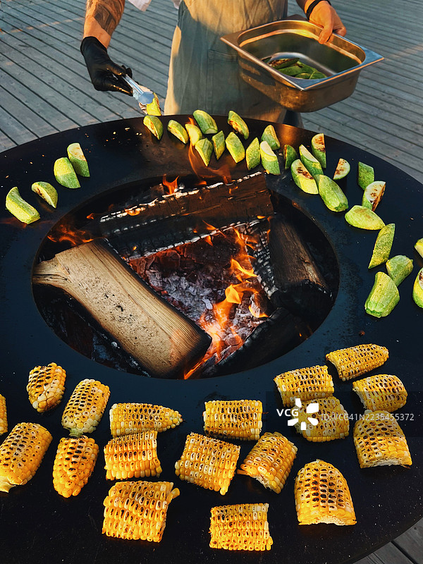 厨师在户外烧烤架上准备烤甜玉米图片素材