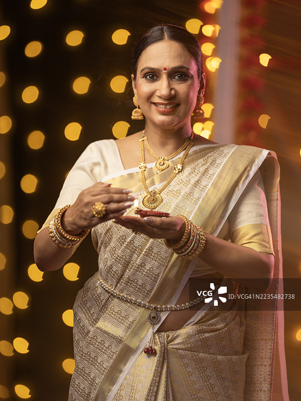 女人在家中庆祝排灯节时手持油灯图片素材