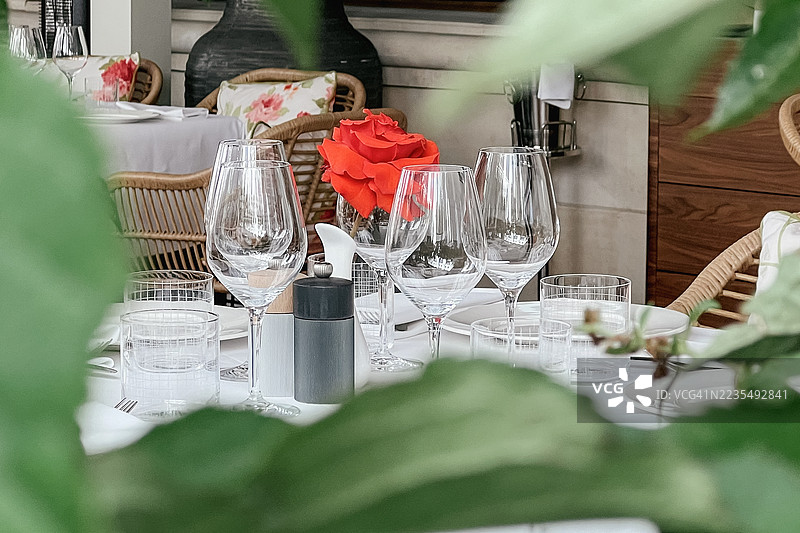 人行道酒店餐厅的桌子上摆放着水晶玻璃器皿和新鲜花卉图片素材