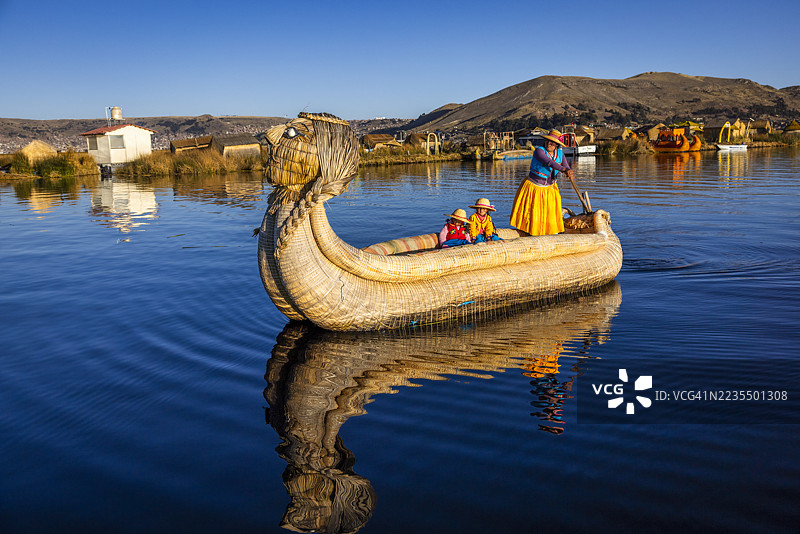 秘鲁年轻女性在的的喀喀湖乌鲁斯浮岛之间航行图片素材