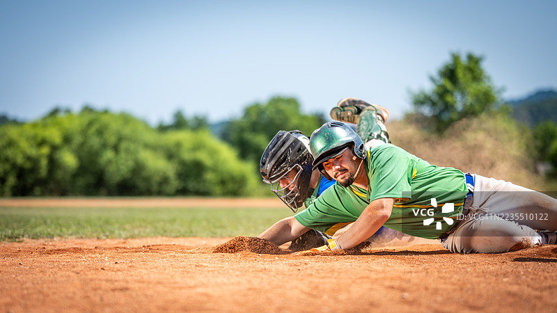 棒球运动员滑入垒包，捕手试图触杀图片素材