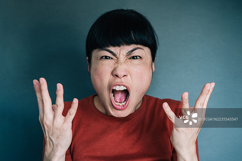 一位亚洲女性在大声喊叫并朝着镜头看。图片素材