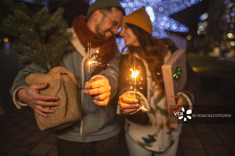 情侣在节日氛围中用烟花和礼物庆祝假期图片素材