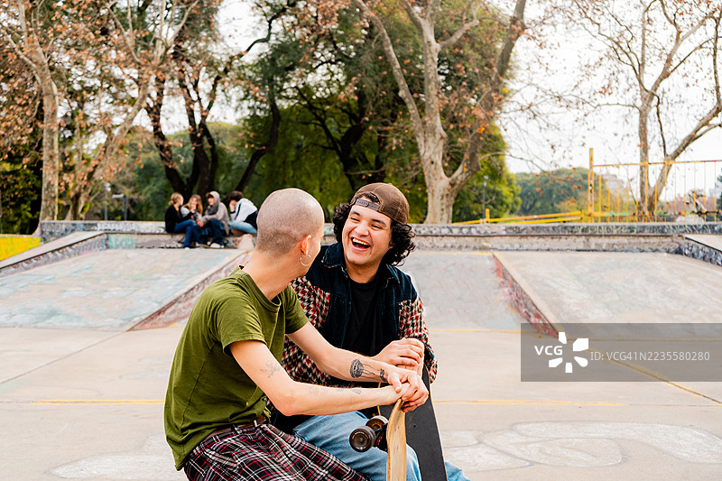 滑板朋友们坐在滑板公园聊天图片素材