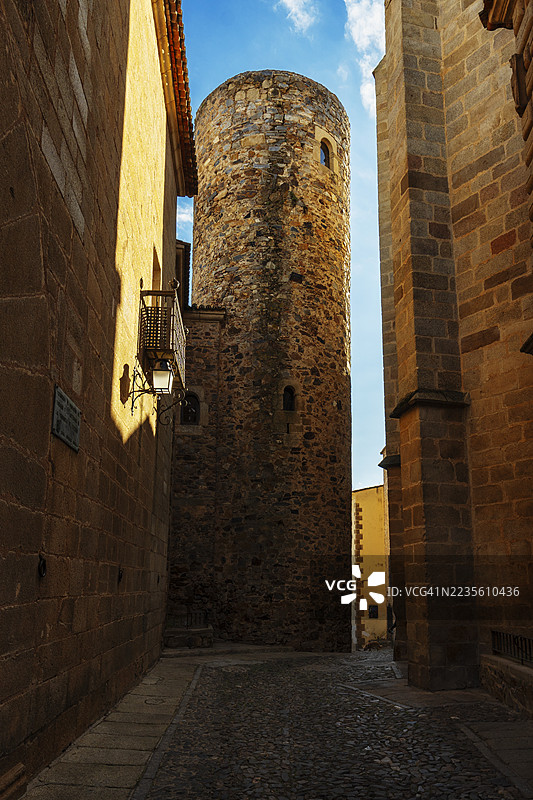 狭窄的街道，背景是卡尔巴卡尔宫塔。卡塞雷斯图片素材