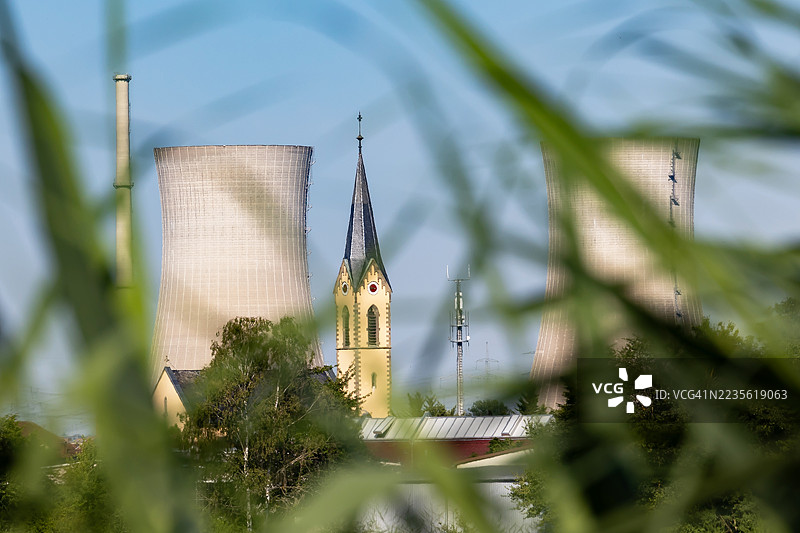 历史悠久的德国传统教堂塔与核电站的冷却塔图片素材