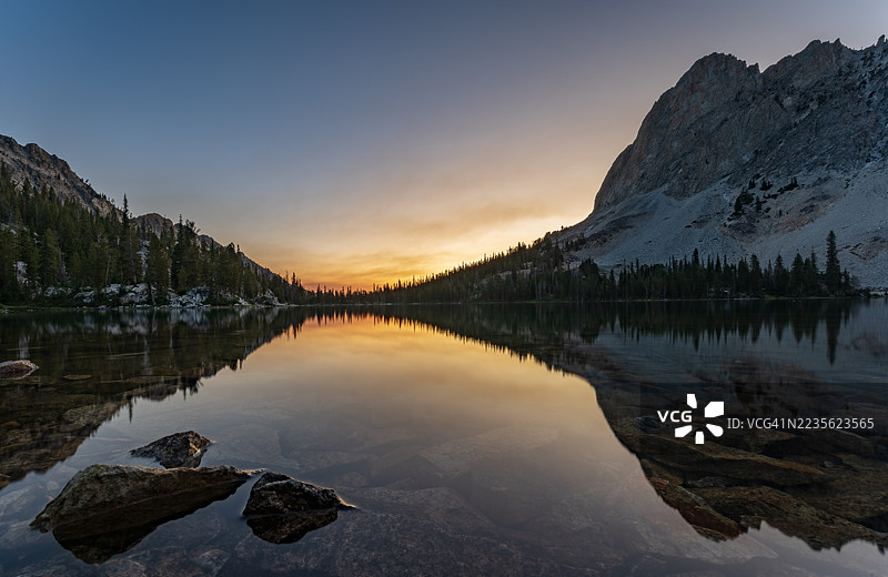 宁静的山湖映照出生动的日落天空和森林环绕的湖岸，美国，索托斯荒野图片素材