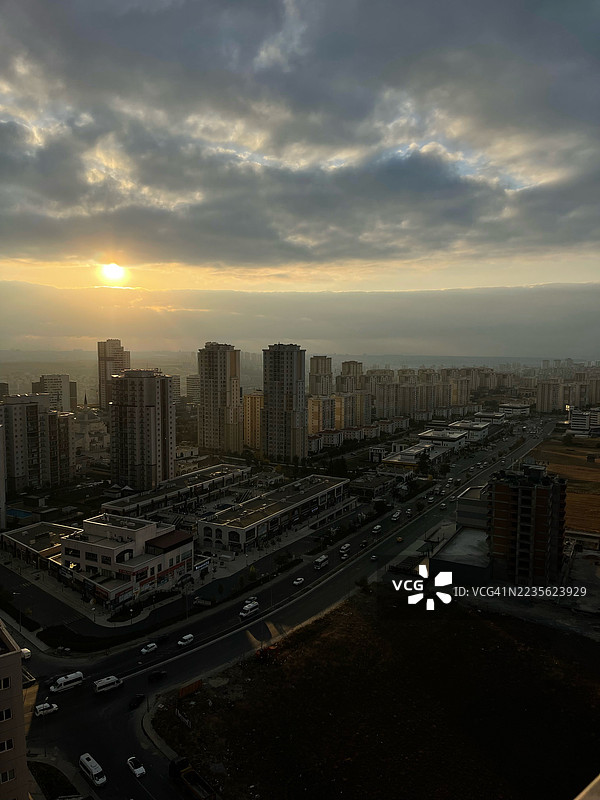 日落时分现代城市的高角度视图，阳光穿透戏剧性的云层，伊斯坦布尔，土耳其图片素材