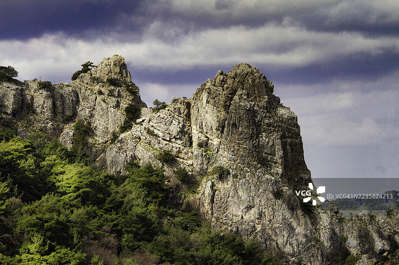 戏剧性的低角度视图，展示了土耳其斯皮尔崎岖的山峰与多云的天空。图片素材