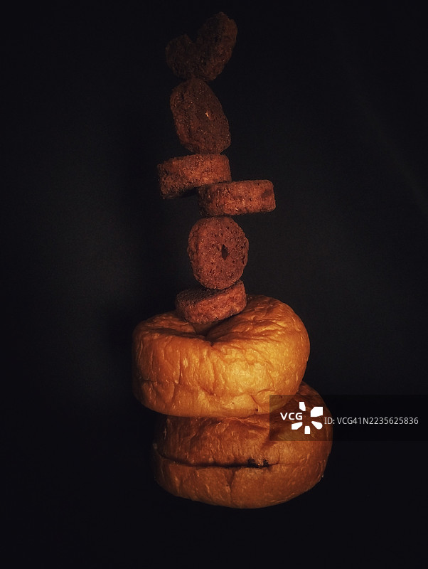 黑色背景上的抽象烘焙食品和饼干堆叠图片素材