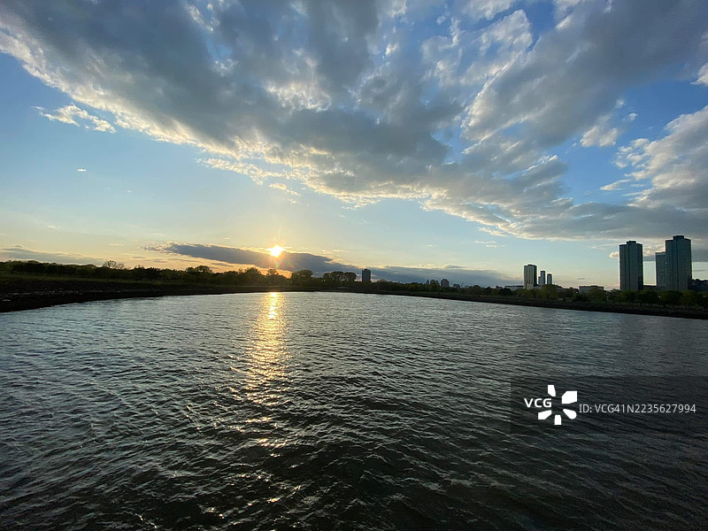 城市天际线与日落天空下的河流美景图片素材