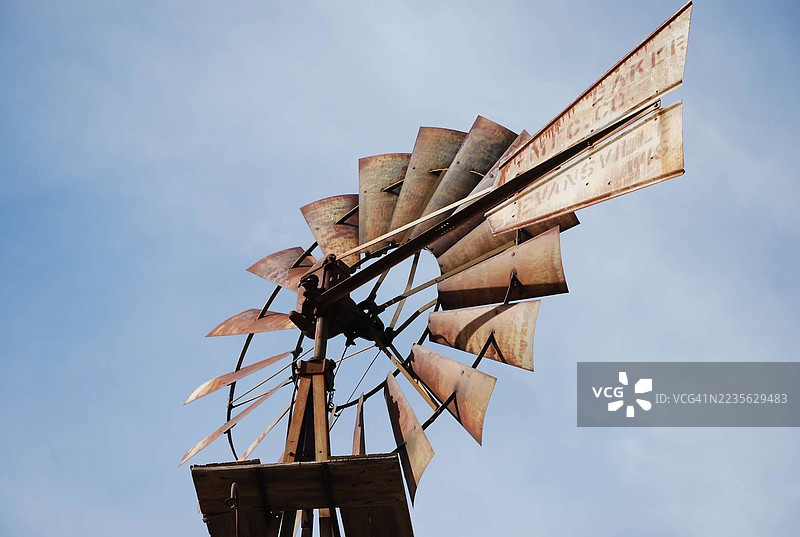 低角度视图下的古老风车，背景是晴朗的蓝天，唤起历史和乡村生活的感觉图片素材