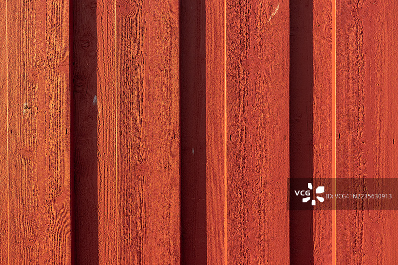 全景特写，展示了风化的红色木板，清晰可见的木纹和质感，适合用作背景或抽象设计。图片素材