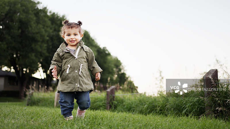 可爱的小女孩在草坪上探索大自然图片素材
