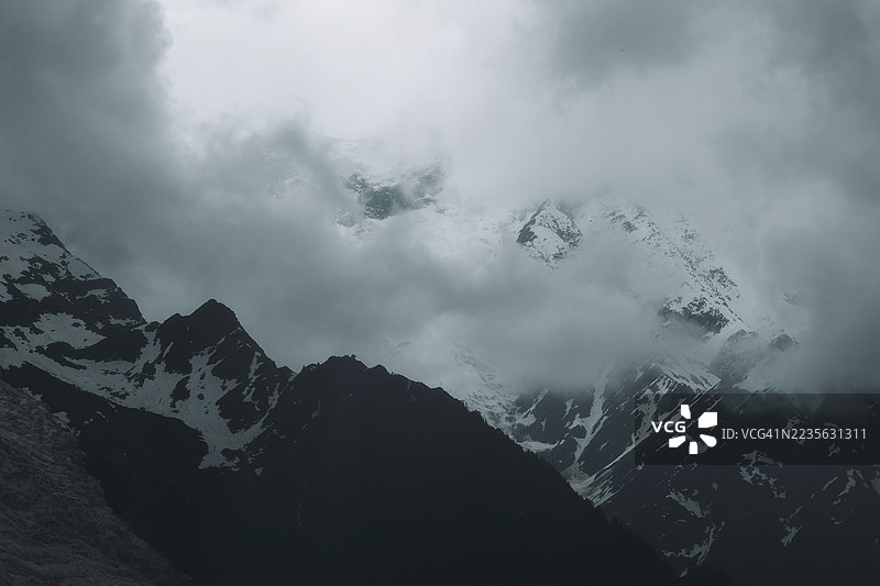 云雾缭绕的雪山壮丽低角度视图，法国博纳维尔图片素材